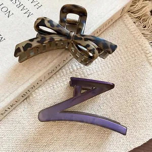 Leopard print bow and geometric purple hair claw clips set on minimalist background