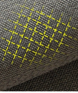 Close-up of gray woven kitchen mat texture with yellow dot pattern detail