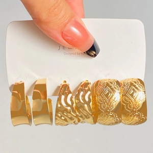 Detailed set of three golden hoop earrings with smooth, wavy, and engraved textures