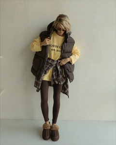 Detail of layered autumn outfit with brown vest, yellow sweatshirt and plaid shirt
