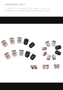 Detail of short black and white heart nails with french tips and wavy lines patterns