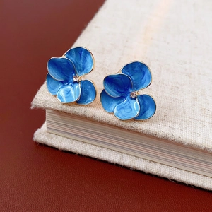 Vintage gold-tone flower earrings with blue enamel petals and sparkling center zirconia