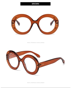 Detail of round amber glasses frame featuring metal rivets and premium acetate texture