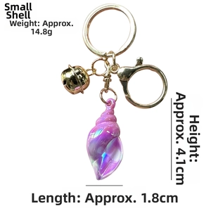 Macro view of colorful conch keychain with size measurements and golden bell detail