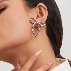 Detail shot of silver bead bow earrings with tassels worn by model for elegant style