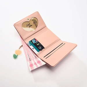 Pink trifold wallet with heart photo window and tulip charm on white background