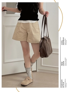 Detail of high-waist khaki wide-leg shorts with cotton linen texture for women