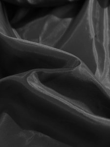 Gros plan sur un tissu noir brillant aux reflets soyeux et aux plis élégants