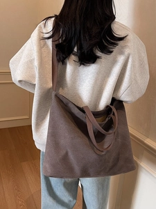 Minimalist coffee canvas tote bag with large capacity shown on a model in a cozy interior