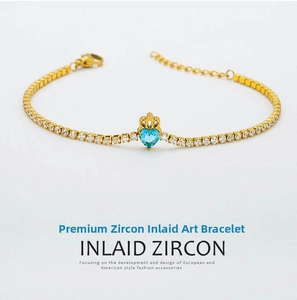 Detailed shot of golden crown bracelet with a light blue heart-shaped cubic zirconia