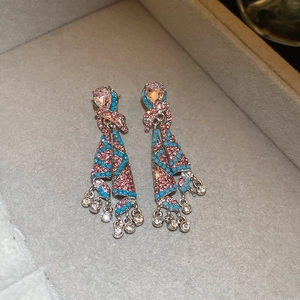 Detailed macro view of vintage rhinestone tassel earrings with pink and blue stones