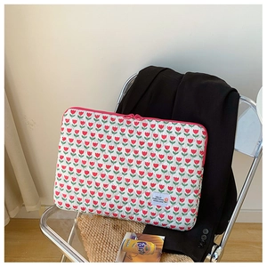 Close-up of quilted cotton laptop sleeve with red tulip print and pink zipper detail