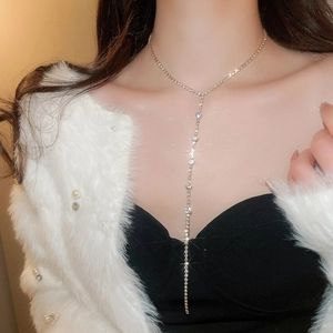 Close-up of sparkling Y-shaped tassel necklace with crystals on a female model