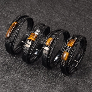 Detail view of four multi-layer braided leather bracelets with natural tiger eye stones