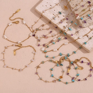 Detail of 18K gold plated stainless steel jewelry with natural stones and pearls on stone