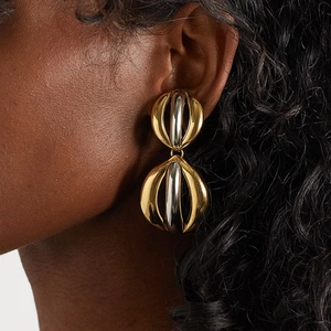 Statement dual-tone gold and silver spherical earrings on model's ear with high polish
