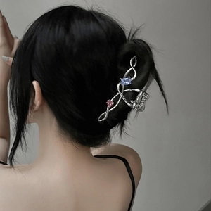 Close-up of Y2K silver metal shark hair claw clip with pink and blue gemstones on hair