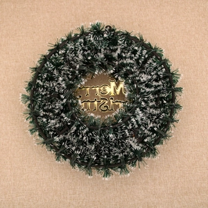Detail of Christmas wreath with green pine needles and golden Merry Christmas sign
