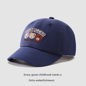 Dettaglio di tre orsetti ricamati su cappellino in cotone blu per bambini