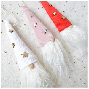 Three plush Christmas gnome ornaments in white pink and red with velvet hats and stars
