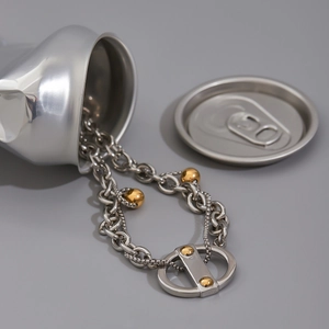 Vue détaillée du collier bicolore en acier sortant d'une canette argentée créative