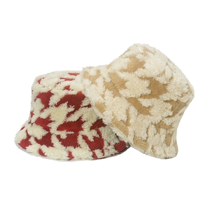 Close-up of fluffy houndstooth bucket hats in red and beige plush for winter warmth