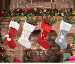 Chaussettes de Noël en tricot avec bordure en fausse fourrure sur une cheminée rustique
