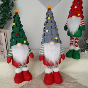 Three Nordic Christmas forest gnomes in red green and grey standing on a bookshelf