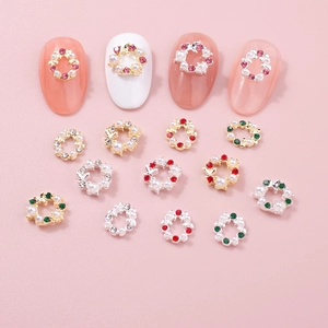 Breloques nail art couronne de Noël avec strass colorés et perles sur manucure
