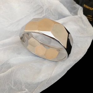 Macro shot of a chunky irregular silver geometric metal bracelet on a black background