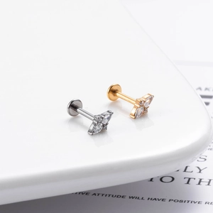 Macro shot of G23 titanium push-pin ear studs featuring zircon flower and crown designs