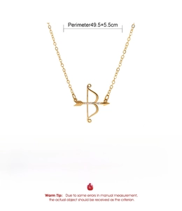 Macro detail of gold Cupid arrow pendant necklace with zircon inlay and copper chain
