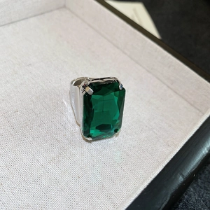 Macro shot of large emerald-cut green crystal set in a silver adjustable band