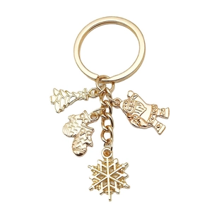 Golden Christmas keychain with Christmas tree, Santa, and snowflake charms on white background