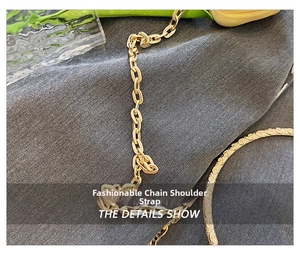 Detailed macro view of glossy golden flat oval metal chain strap on textured fabric