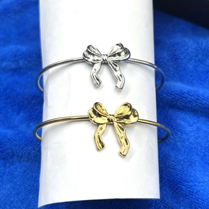 Détail des bracelets noeuds en finitions dorée et argentée sur fond de velours bleu