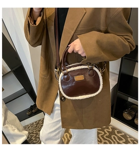 Detail of vintage brown leather bowling bag with faux fur trim shown on model
