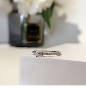 Macro shot of silver square cut cubic zirconia ring on elegant white geometric stand