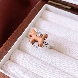 Macro shot of wooden rocking horse ring with sparkling zircon details on a velvet background