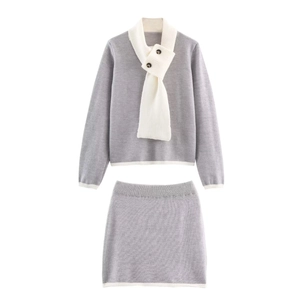 Detalle del conjunto de punto gris con cuello bufanda blanco y botones decorativos
