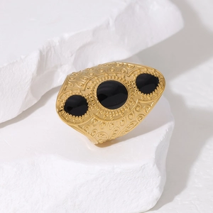 Macro shot of vintage 18K gold plated ring with black gemstones and intricate engraving