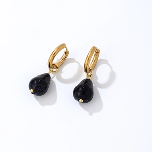 Detailed macro view of gold-polished earrings featuring deep blue teardrop sandstone charms
