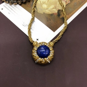 Detailed view of vintage gold necklace with blue lapis stone and rhinestone accents