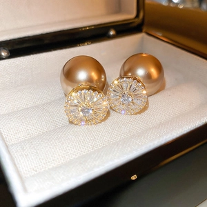 Macro shot of vintage gold pearl earrings with zircon inlay in a velvet jewelry box