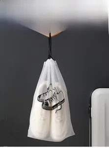 Detail of frosted drawstring storage bag with sneaker print beside a white suitcase
