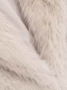 Détail de la fourrure synthétique beige et de la doublure en satin lisse d'une veste