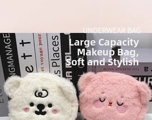 Detail of plush bear cosmetic bags in pink and white with delicate embroidered expressions