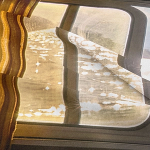 Close-up of bohemian tapestry fabric texture featuring a scenic window landscape print