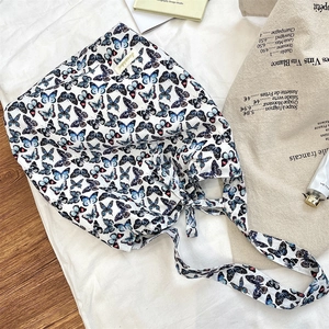 Close-up of white canvas tote bag featuring vibrant blue and black butterfly prints