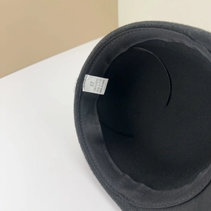 Détail des coutures internes et de l'étiquette d'entretien sur une casquette noire